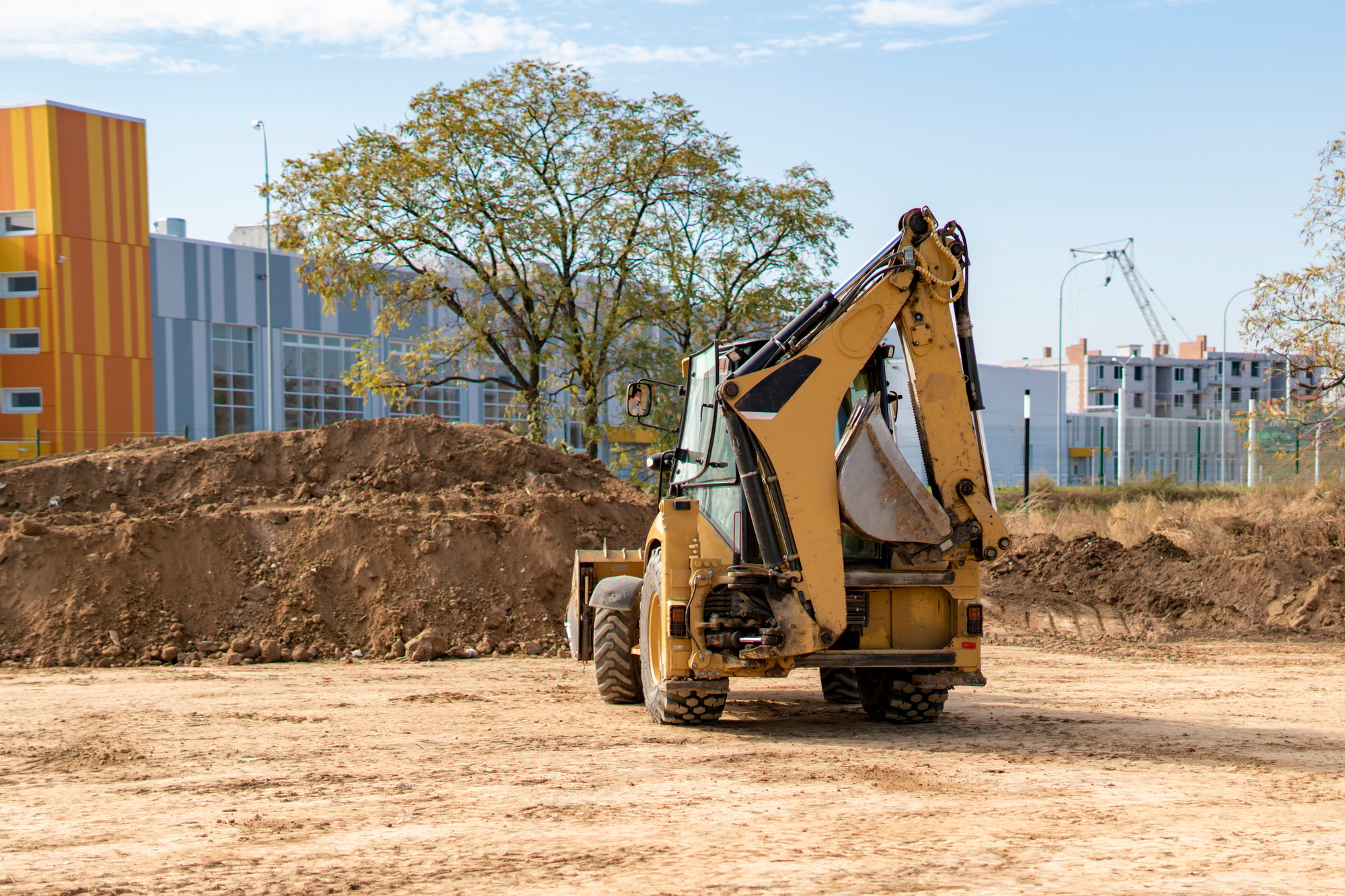 excavator bulldozer machine working to build the new apartment complex