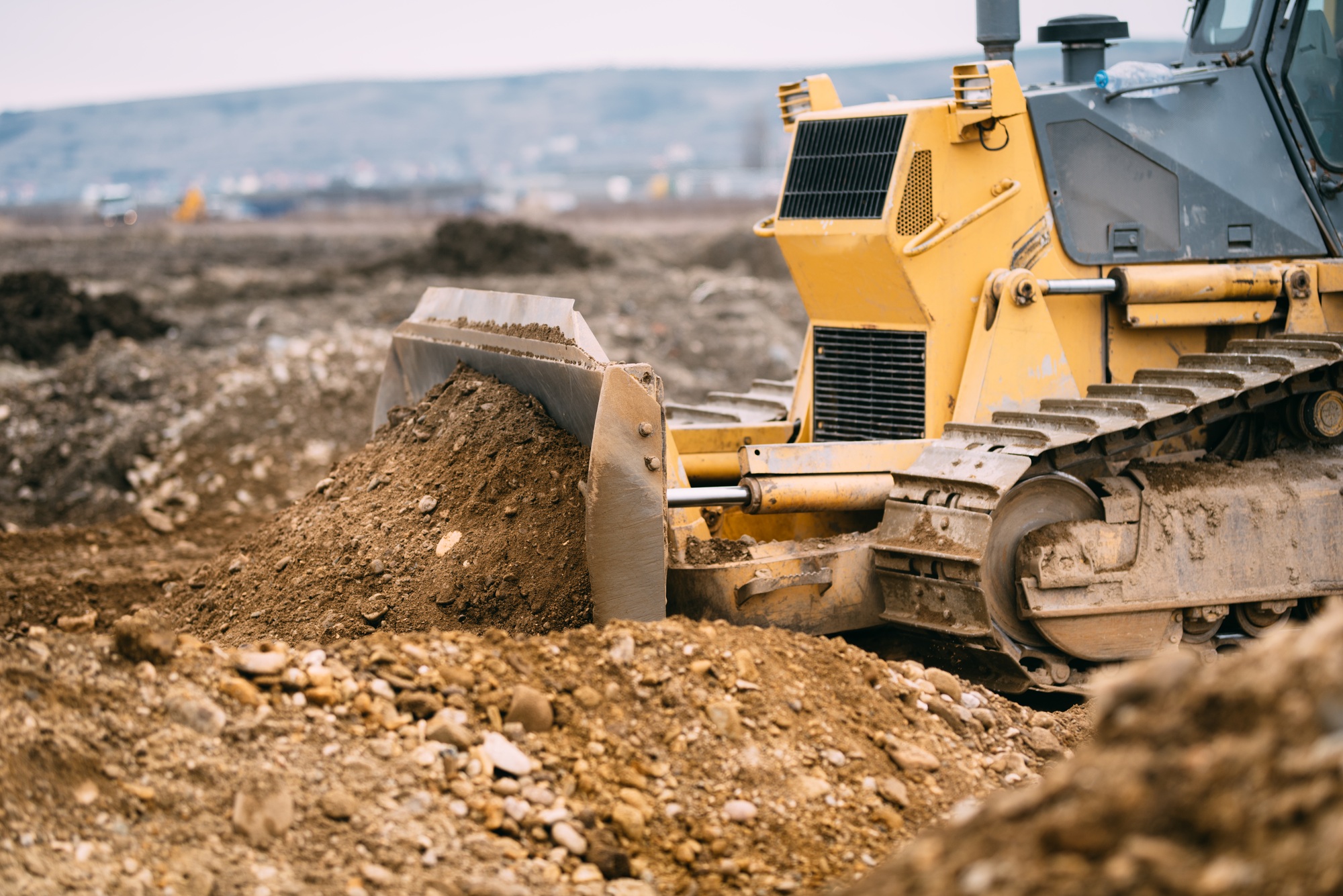 highway construction site close up with industrial machinery, excavator and bulldozer working