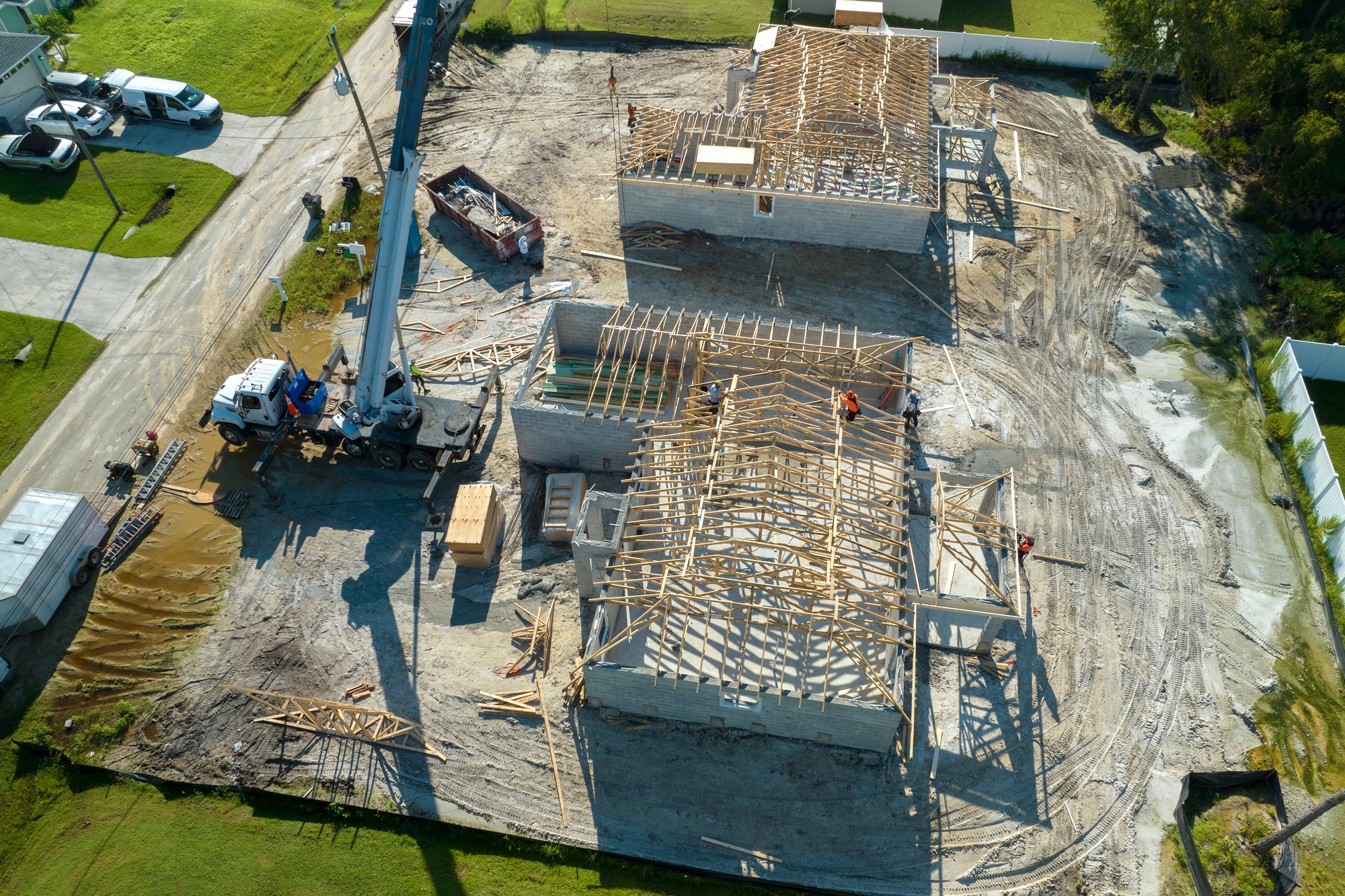 Professional builders and crane truck working on roof construction