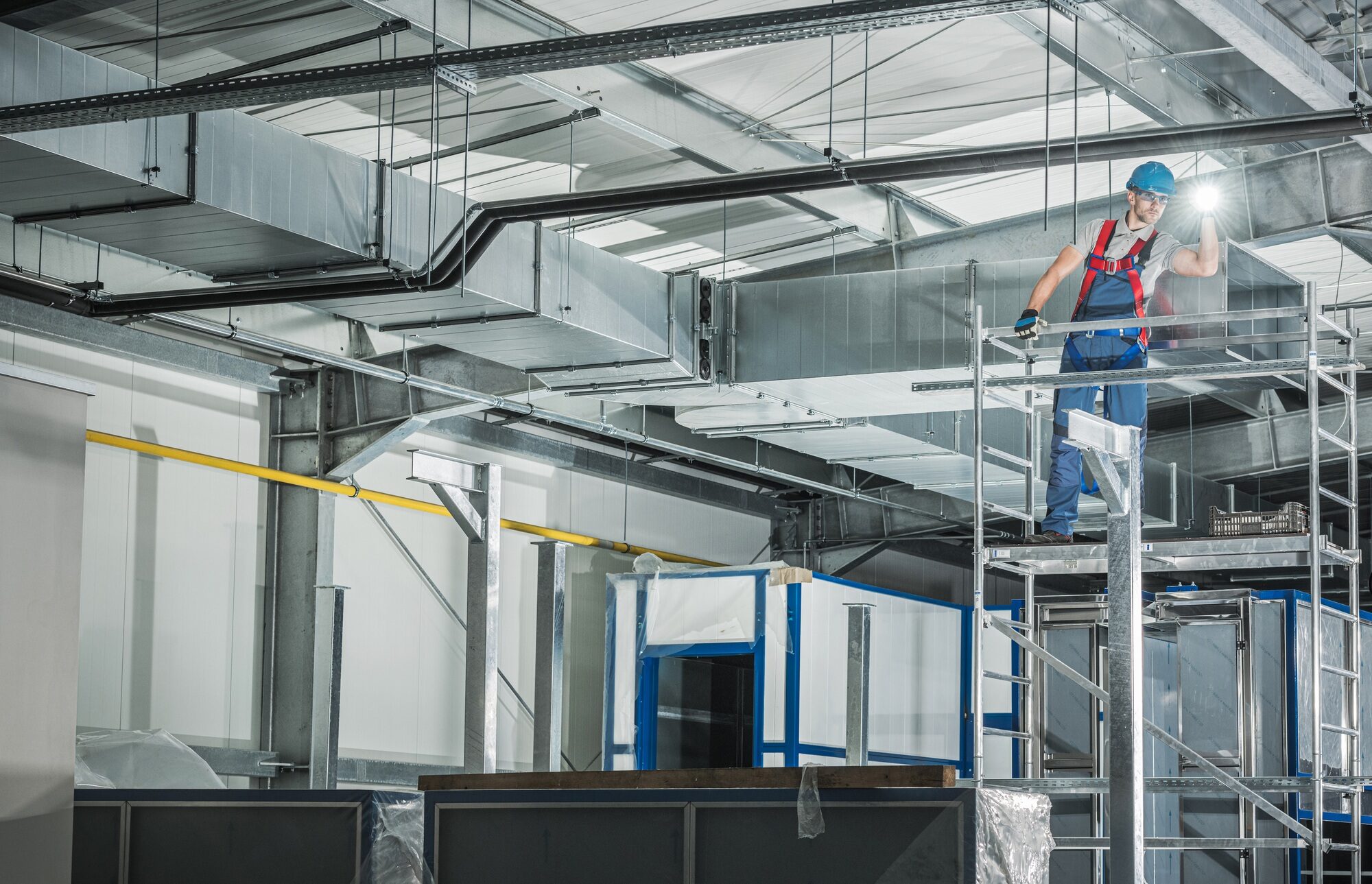 Professional HVAC Technician with Flashlight Overlooking Finished Air Ventilation System