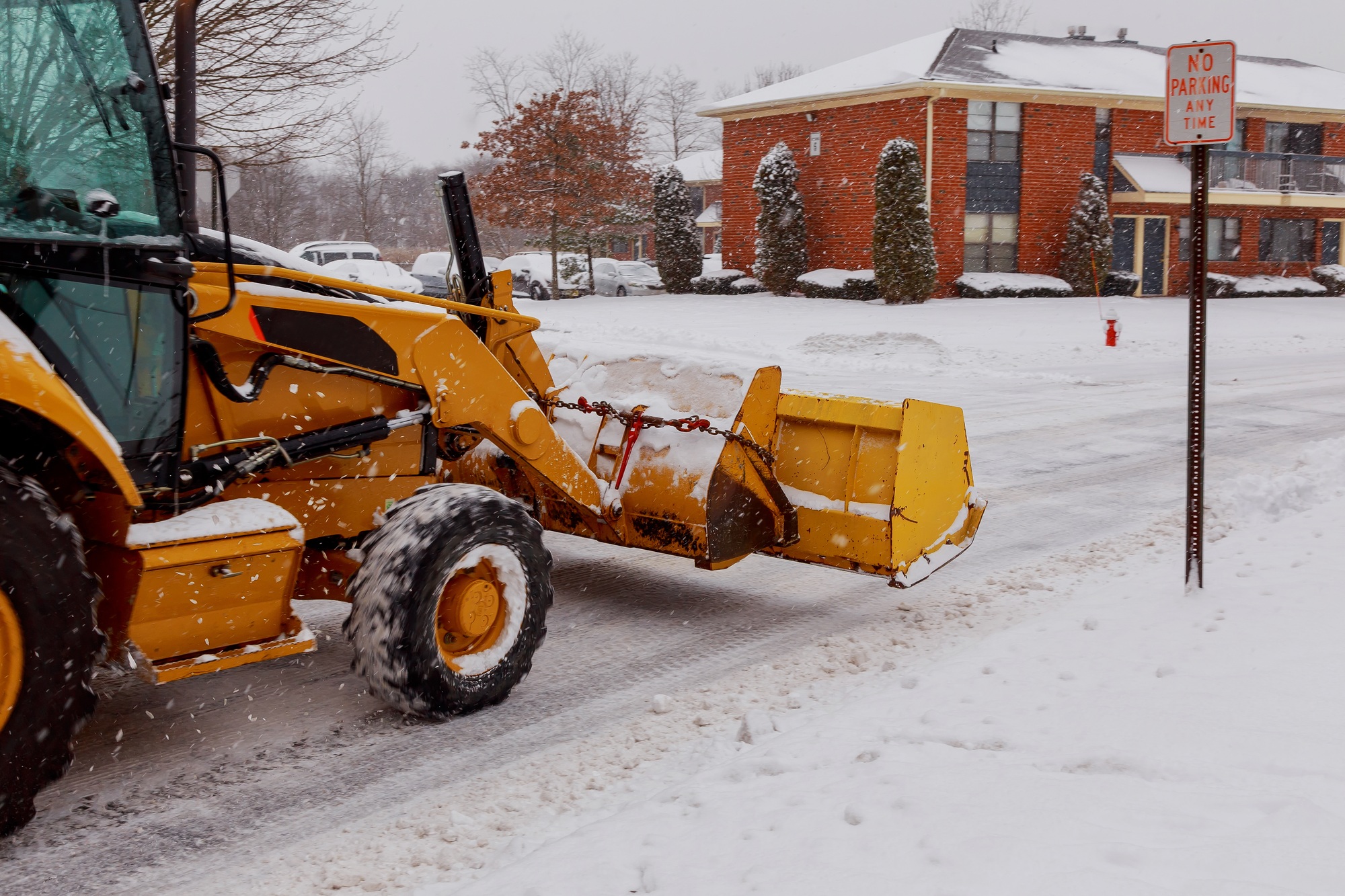 Snow plow doing removal after a blizzard in suberb.