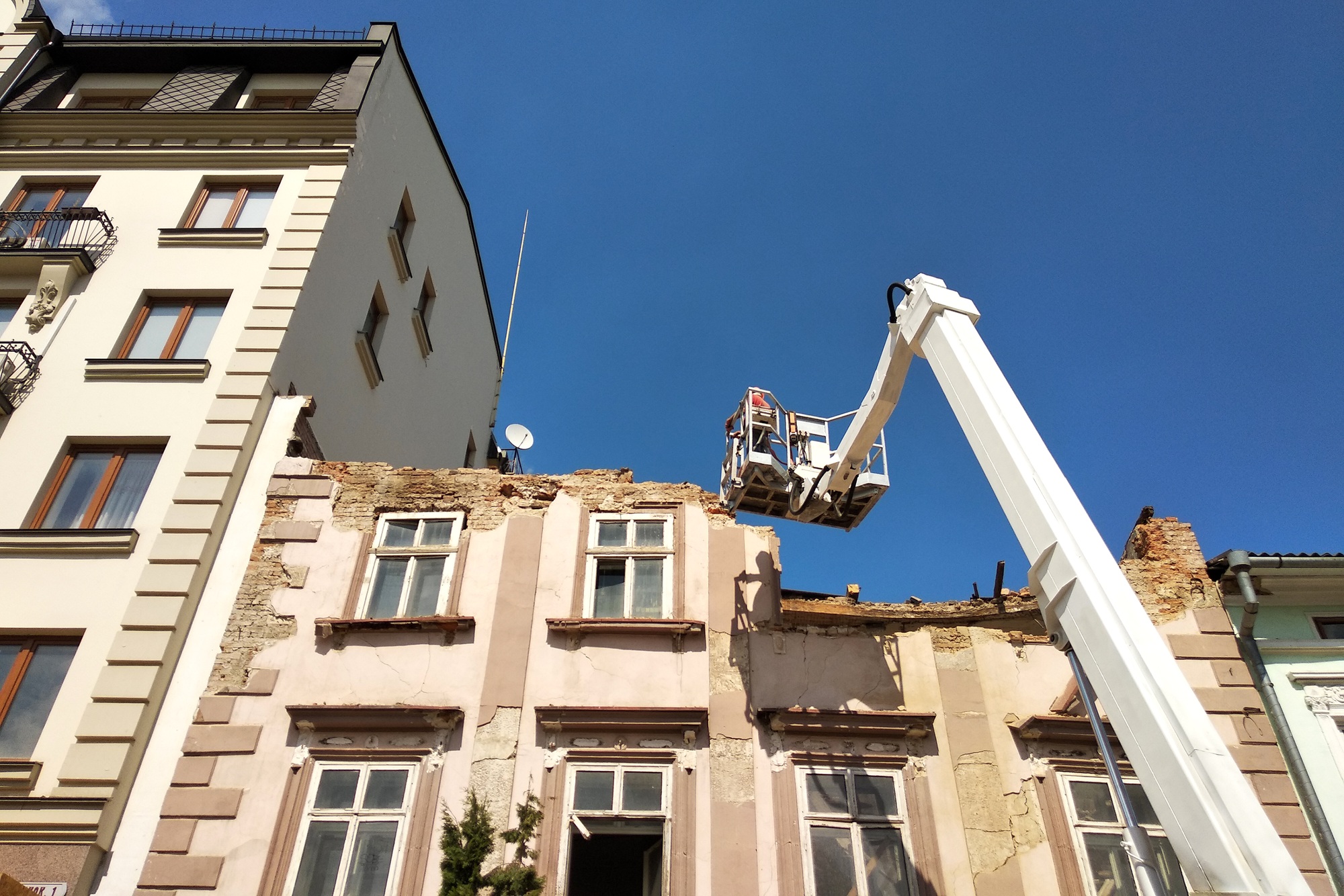 Tower of lift crane and old building under dismantling.